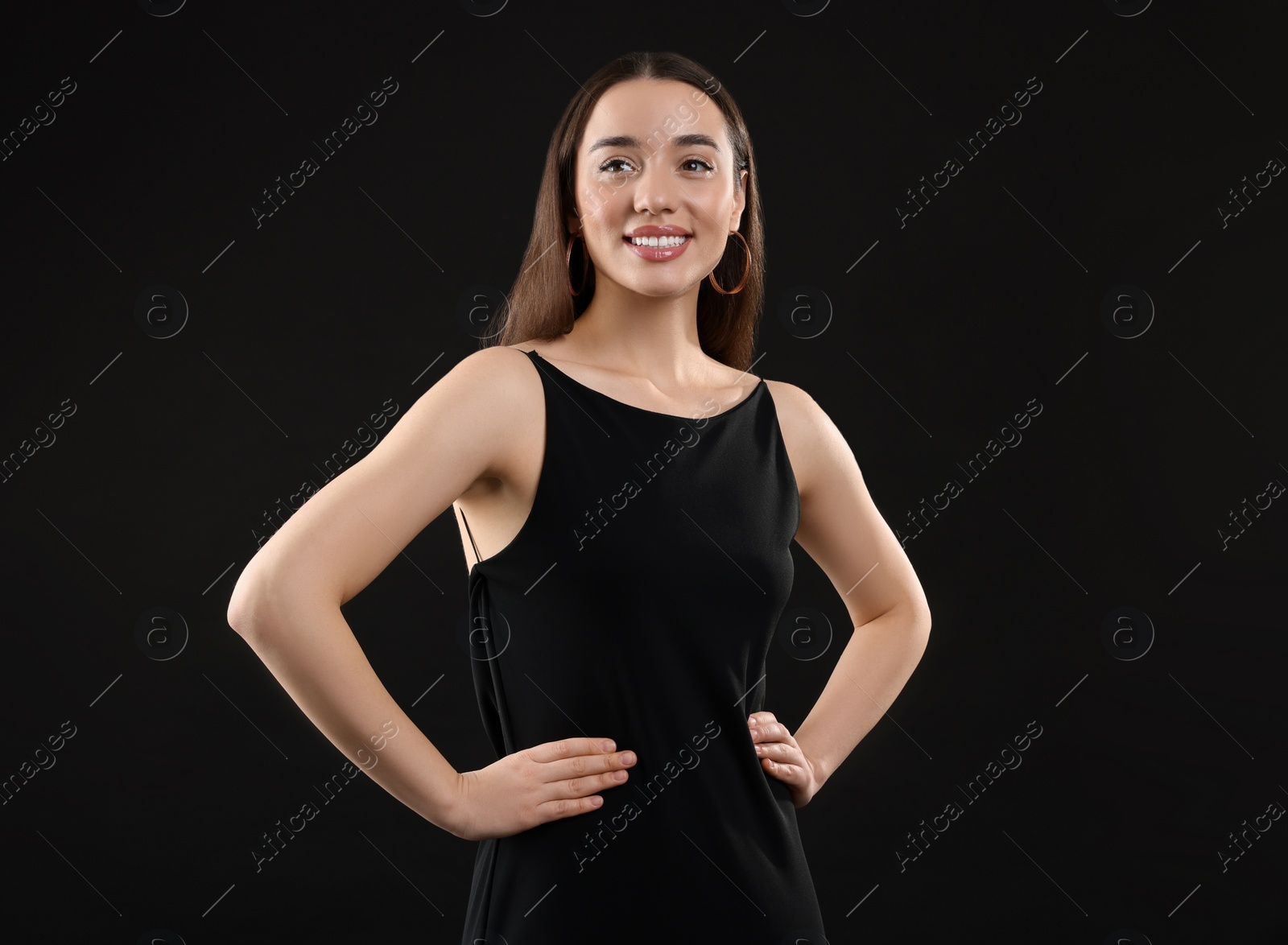 Photo of Beautiful young woman in elegant dress on black background