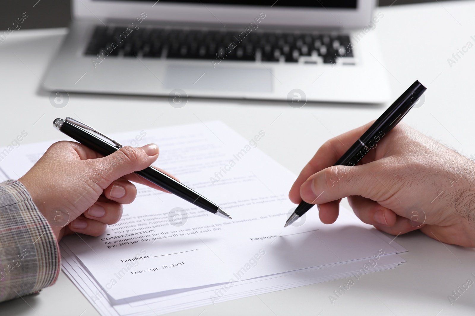 Photo of Businesspeople signing contract at white table, closeup of hands