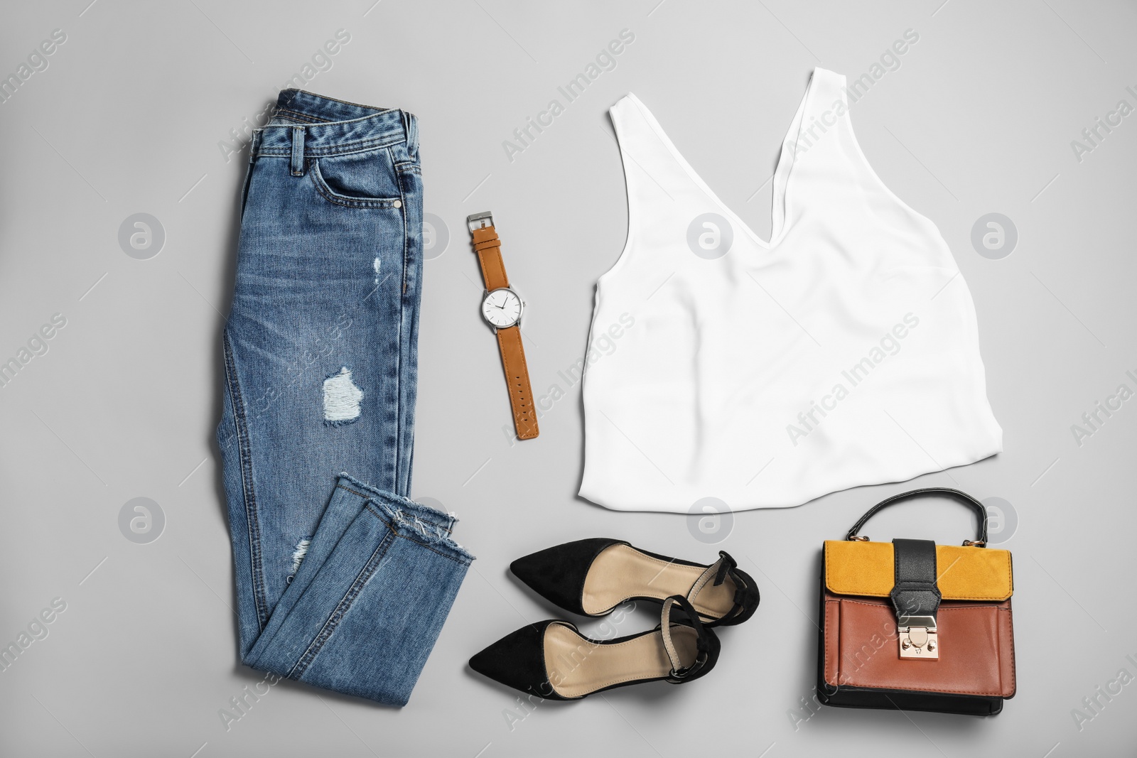 Photo of Stylish outfit with jeans on light grey background, flat lay