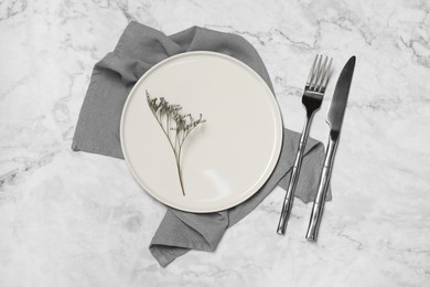 Photo of Stylish setting with elegant cutlery on white marble table, top view