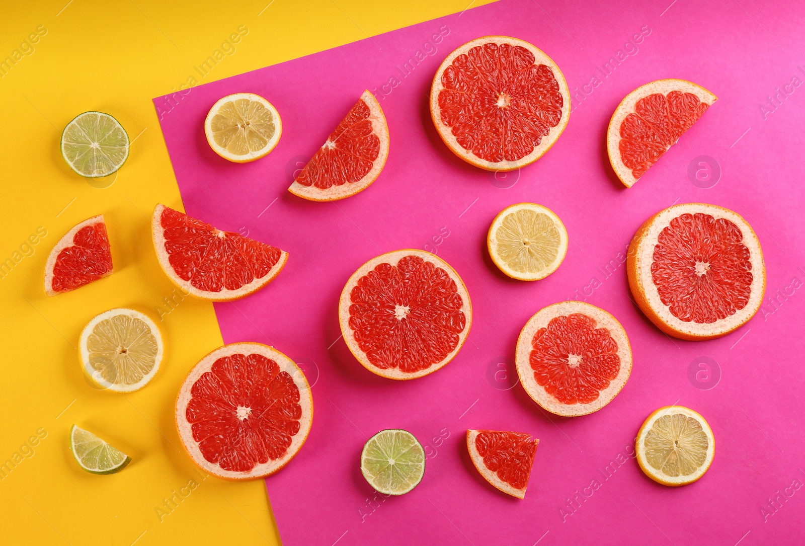 Photo of Flat lay composition with tasty ripe grapefruit slices on color background