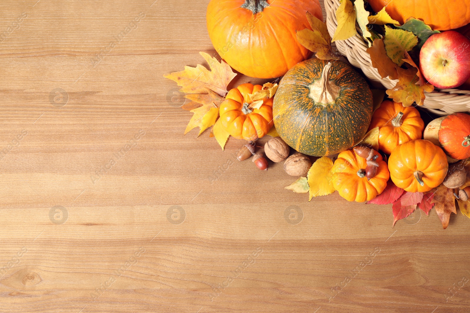 Photo of Flat lay composition with ripe pumpkins and autumn leaves on wooden table, space for text. Happy Thanksgiving day