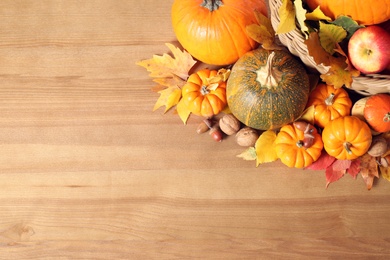 Photo of Flat lay composition with ripe pumpkins and autumn leaves on wooden table, space for text. Happy Thanksgiving day