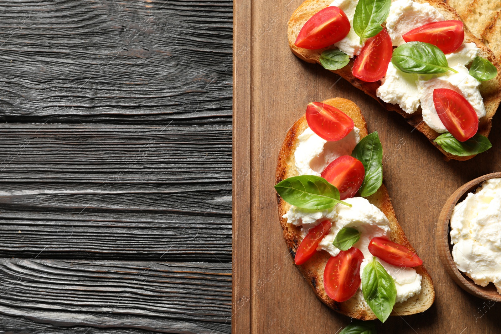 Photo of Toasted bread with tasty cream cheese and tomatoes on wooden table, flat lay. Space for text