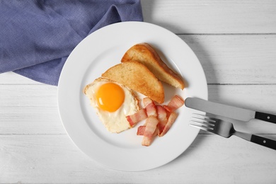 Photo of Fried egg with bacon and toasted bread on plate served for breakfast, top view