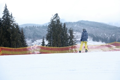 Photo of Snowboarder on slope at resort. Winter vacation
