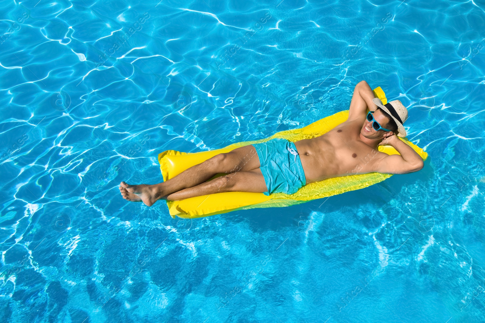 Image of Young man with inflatable mattress in swimming pool. Summer vacation
