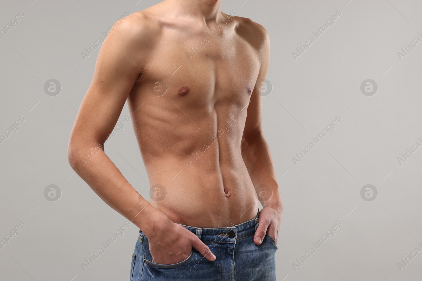 Photo of Shirtless man with slim body on grey background, closeup