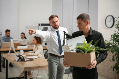 Photo of Boss dismissing man from work in office