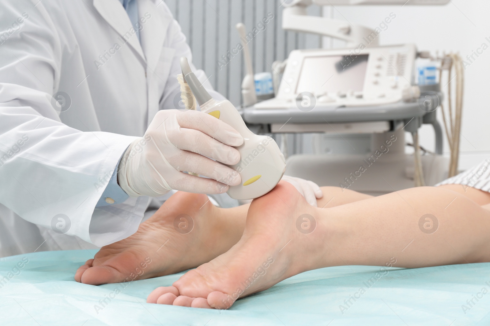 Photo of Doctor conducting ultrasound examination of patient's foot in clinic, closeup