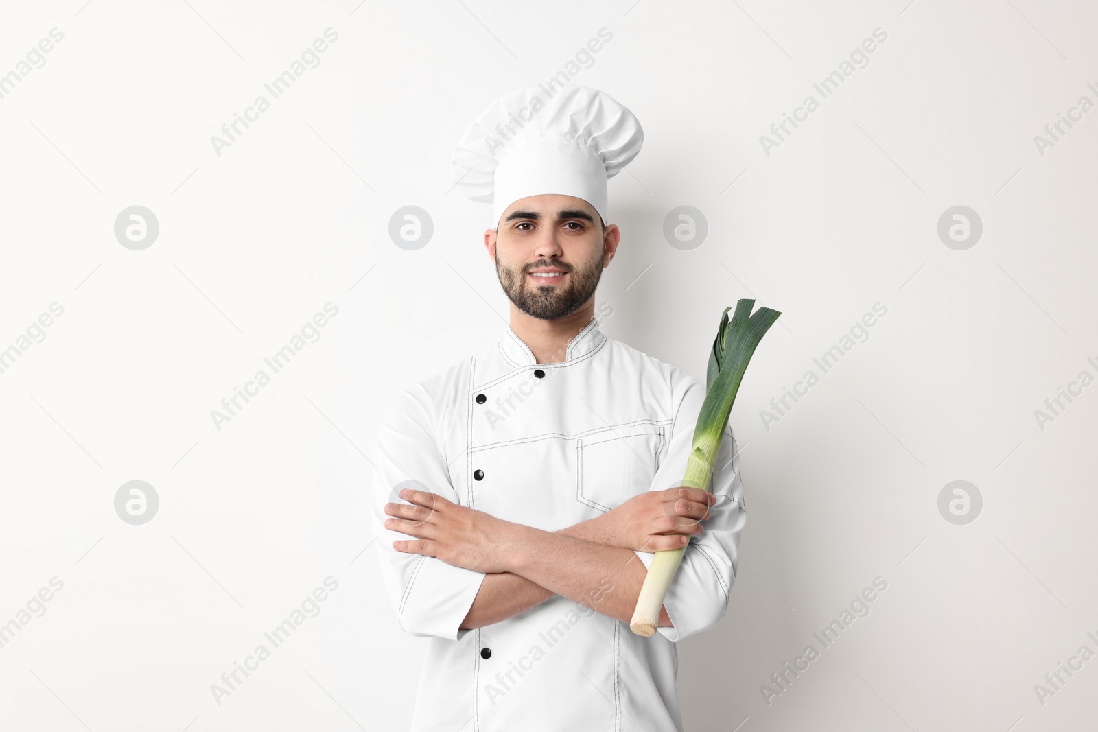 Photo of Professional chef holding leek on white background