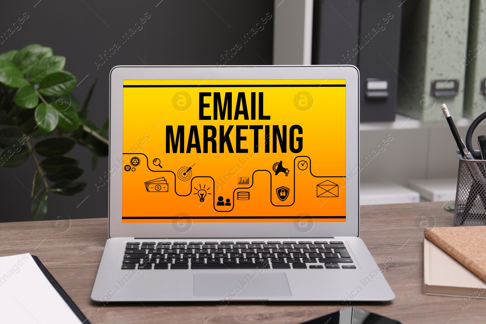 Image of Email marketing. Laptop with icons on screen in office