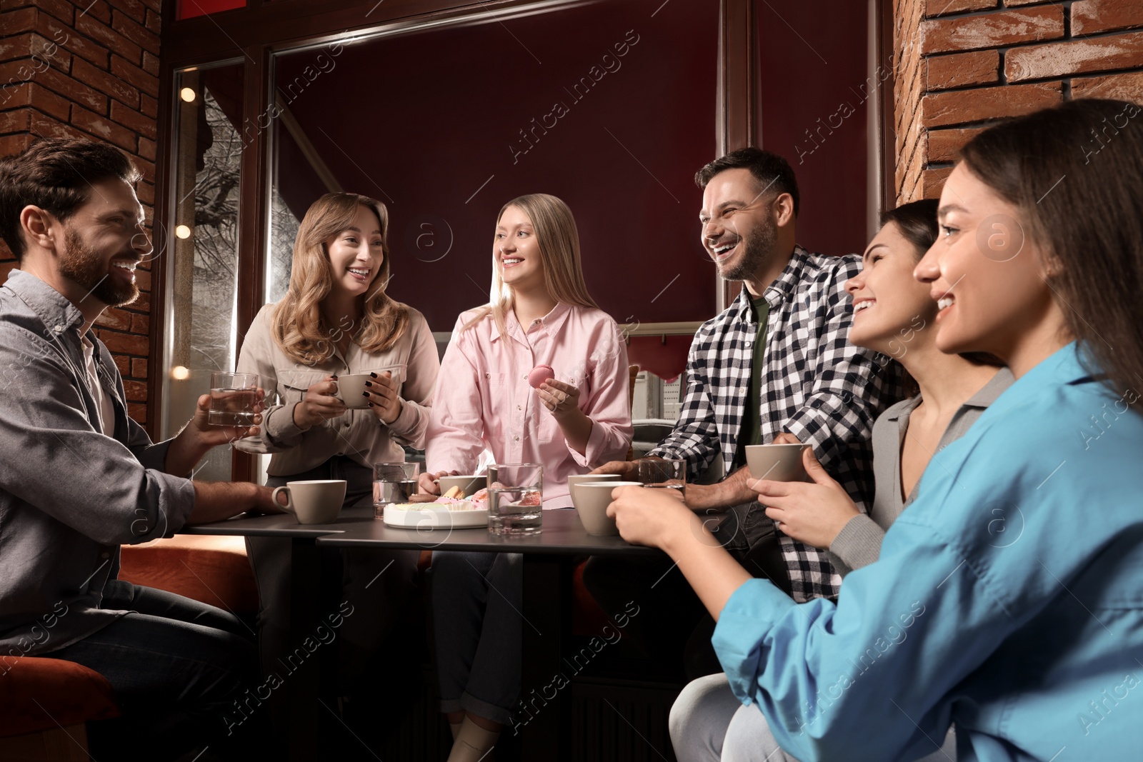 Photo of Friends with coffee spending time together in cafe