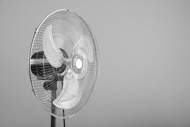 Electric fan on light grey background, space for text. Summer heat