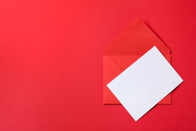 Photo of Letter envelope and card on red background, top view. Space for text