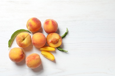 Photo of Fresh sweet peaches on wooden table, top view