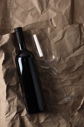 Photo of Stylish presentation of delicious red wine in bottle and glass on paper background, top view