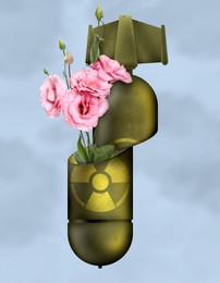 Prevent nuclear war. Broken atomic weapon with flowers inside on light blue background