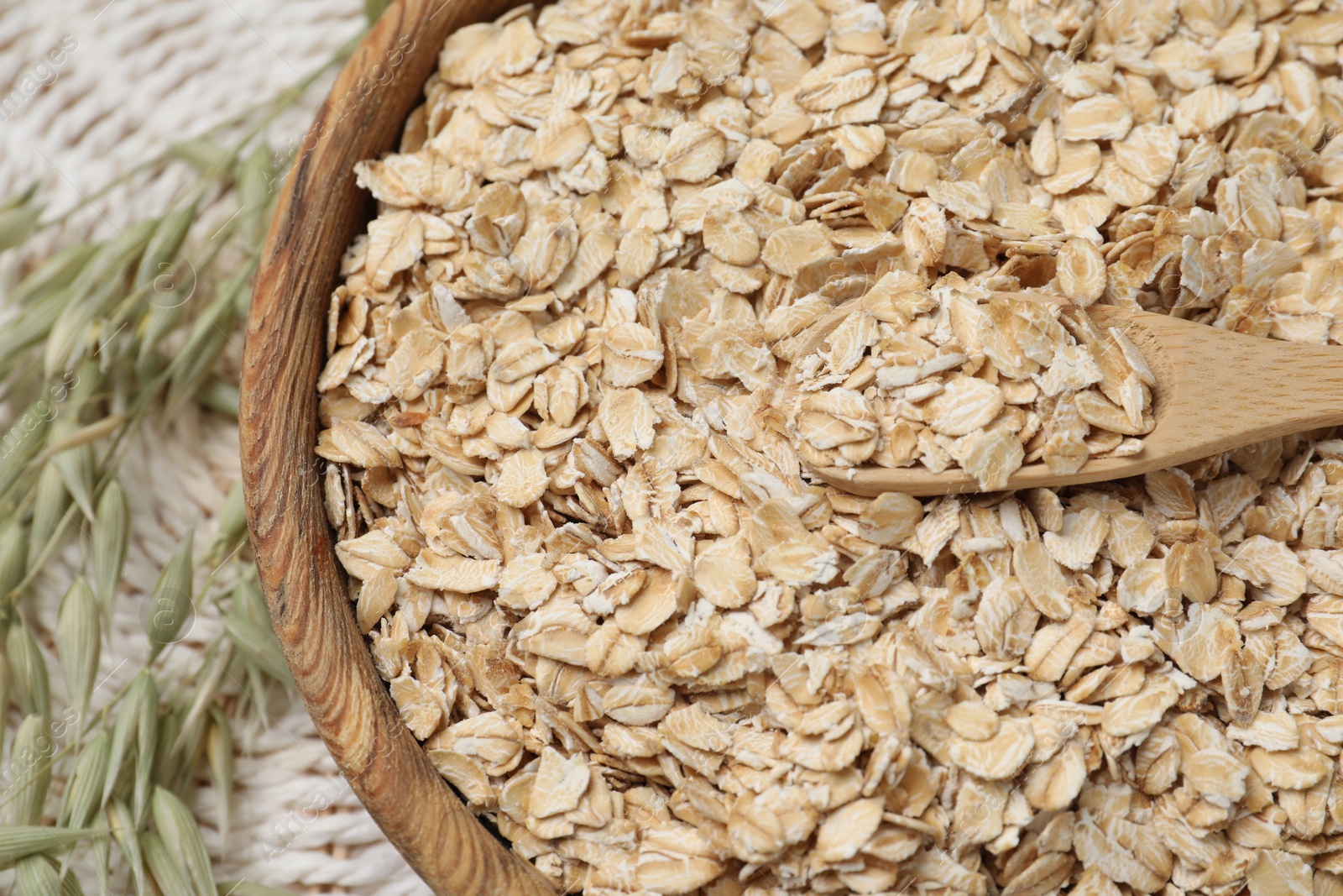 Photo of Bowl and spoon of oatmeal with florets on table, top view