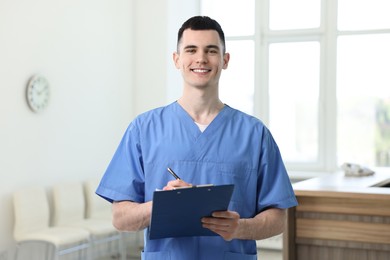 Photo of Portrait of smiling medical assistant with clipboard in hospital