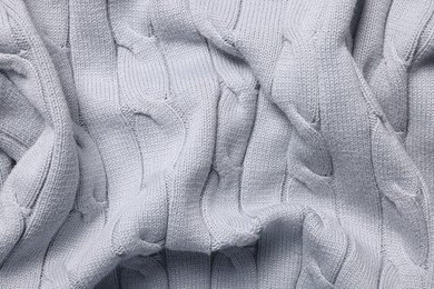 Photo of Texture of light grey knitted fabric as background, top view