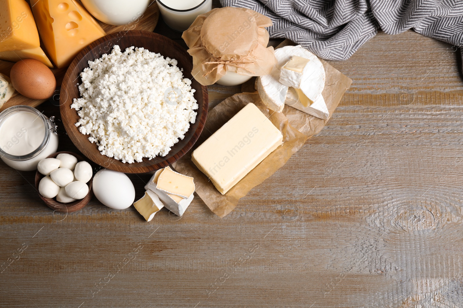 Photo of Different dairy products on wooden table, flat lay. Space for text