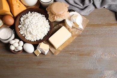 Photo of Different dairy products on wooden table, flat lay. Space for text