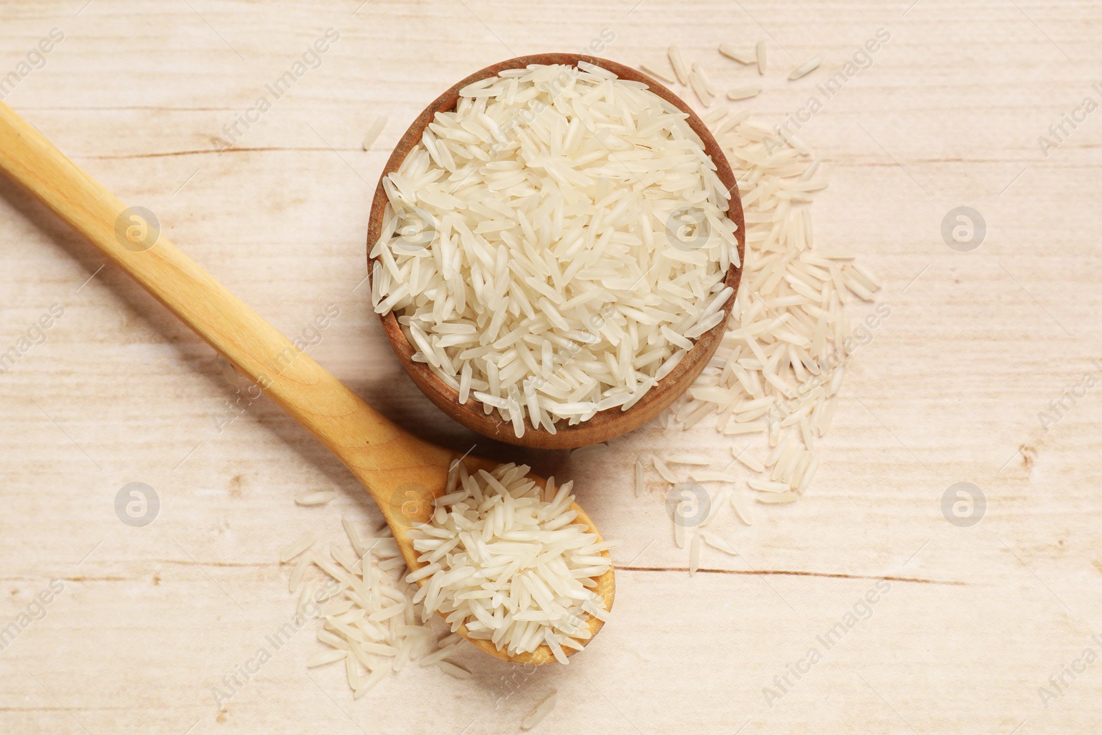 Photo of Uncooked raw basmati rice on white wooden table, flat lay