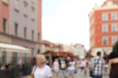 Blurred view of crowded city street on sunny day