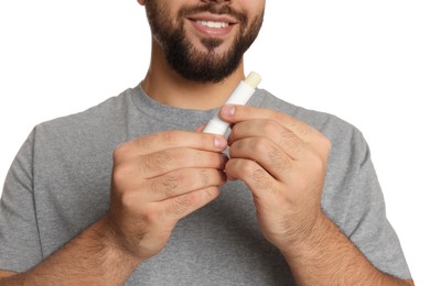 Photo of Young man with lip balm on white background, closeup