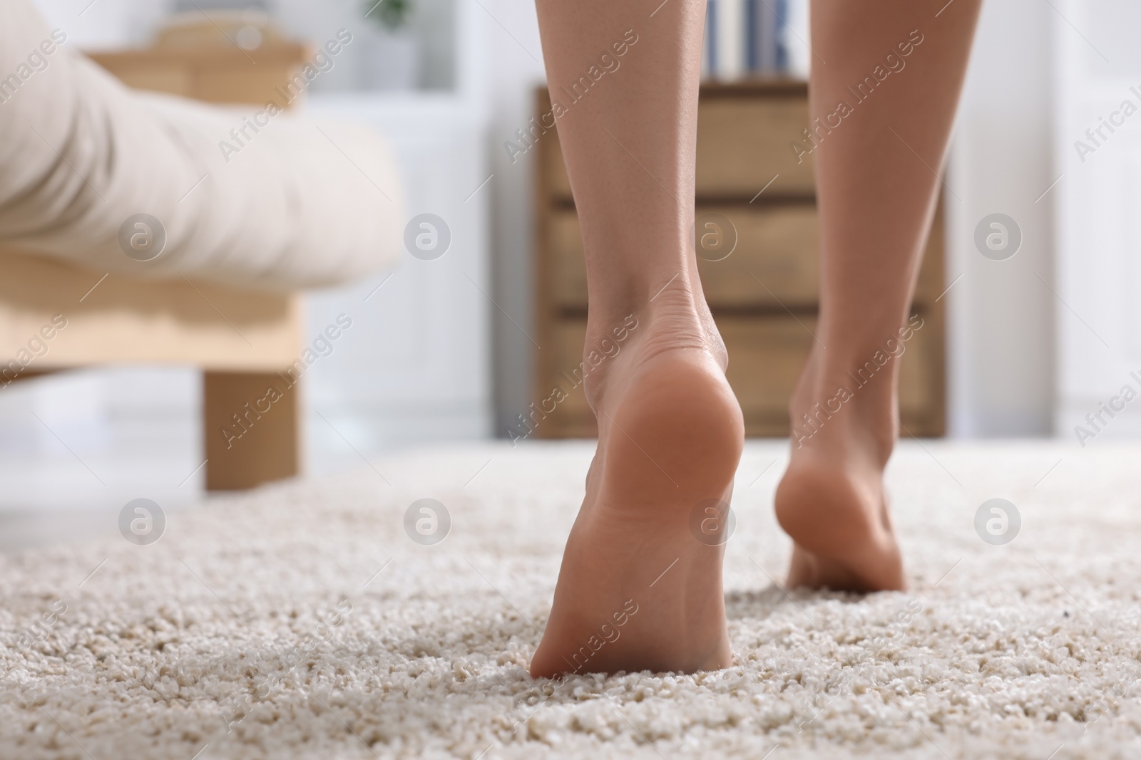 Photo of Woman walking on soft light brown carpet at home, closeup. Space for text