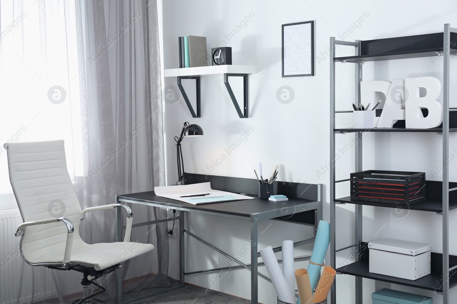 Photo of Stylish room interior with comfortable workplace near window. Design idea