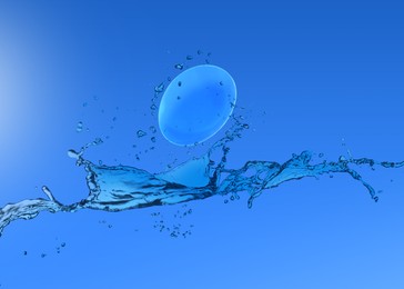 Contact lens and splash of solution on blue background