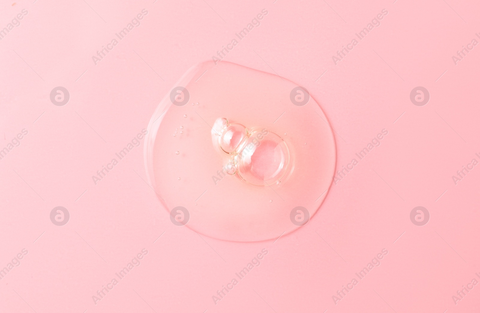 Photo of Drop of hydrophilic oil on pink background, top view
