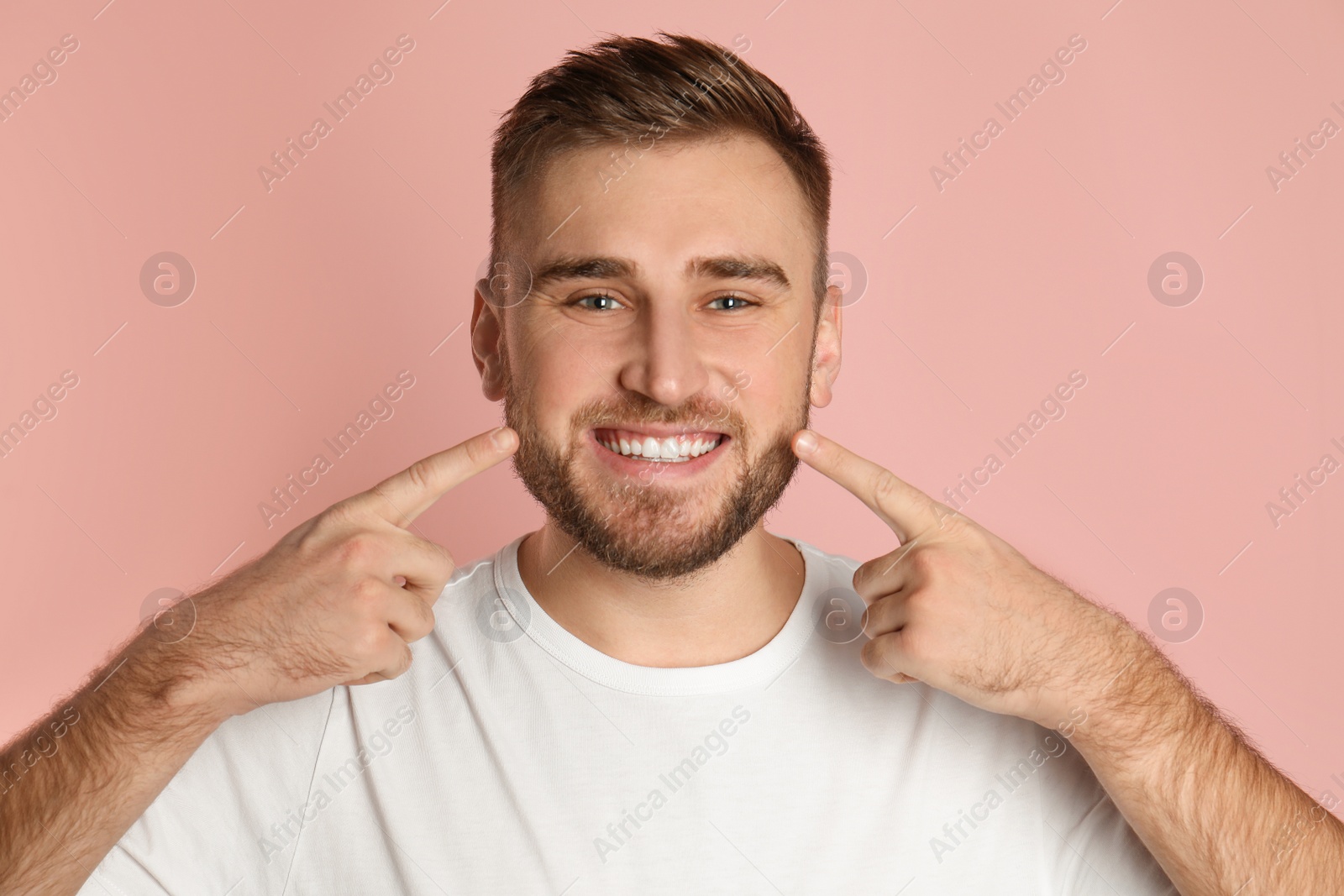 Photo of Young man with healthy teeth on color background