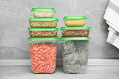 Photo of Plastic containers filled with food products on grey table