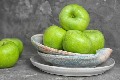 Plate with fresh green apples on table