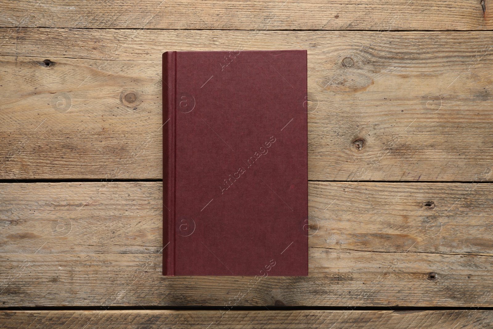 Photo of Closed hardcover book on wooden table, top view