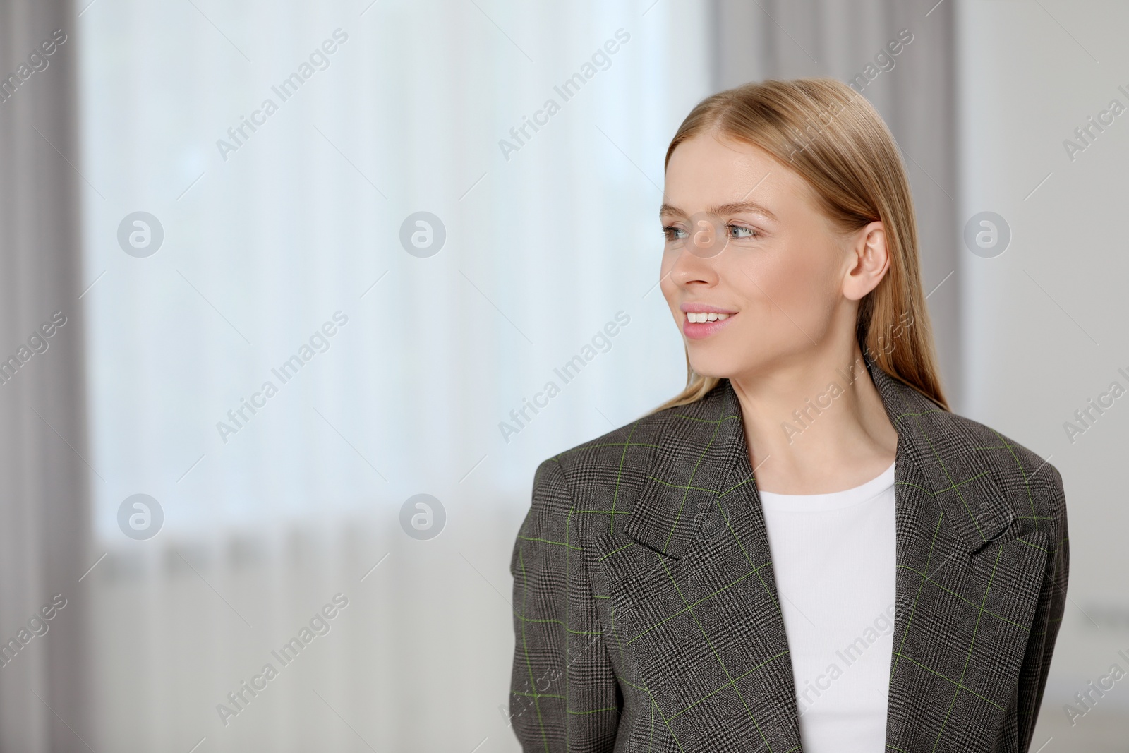 Photo of Portrait of beautiful young woman in stylish jacket indoors. Space for text