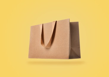 Image of Kraft paper bag on yellow background. Mockup for design