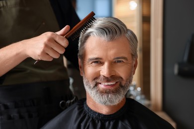 Hair styling. Professional hairdresser working with happy client in barbershop, closeup