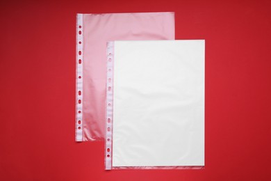 Photo of Punched pockets on red background, flat lay. Space for text