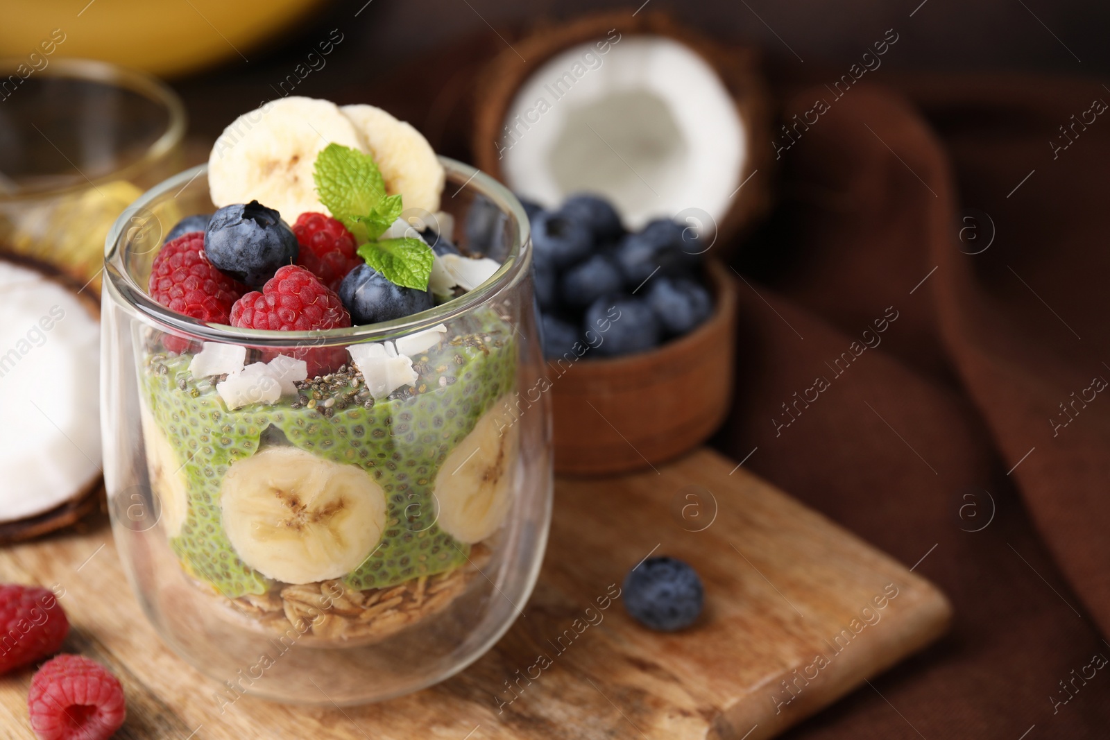 Photo of Tasty oatmeal with chia matcha pudding and fruits on wooden board, space for text. Healthy breakfast