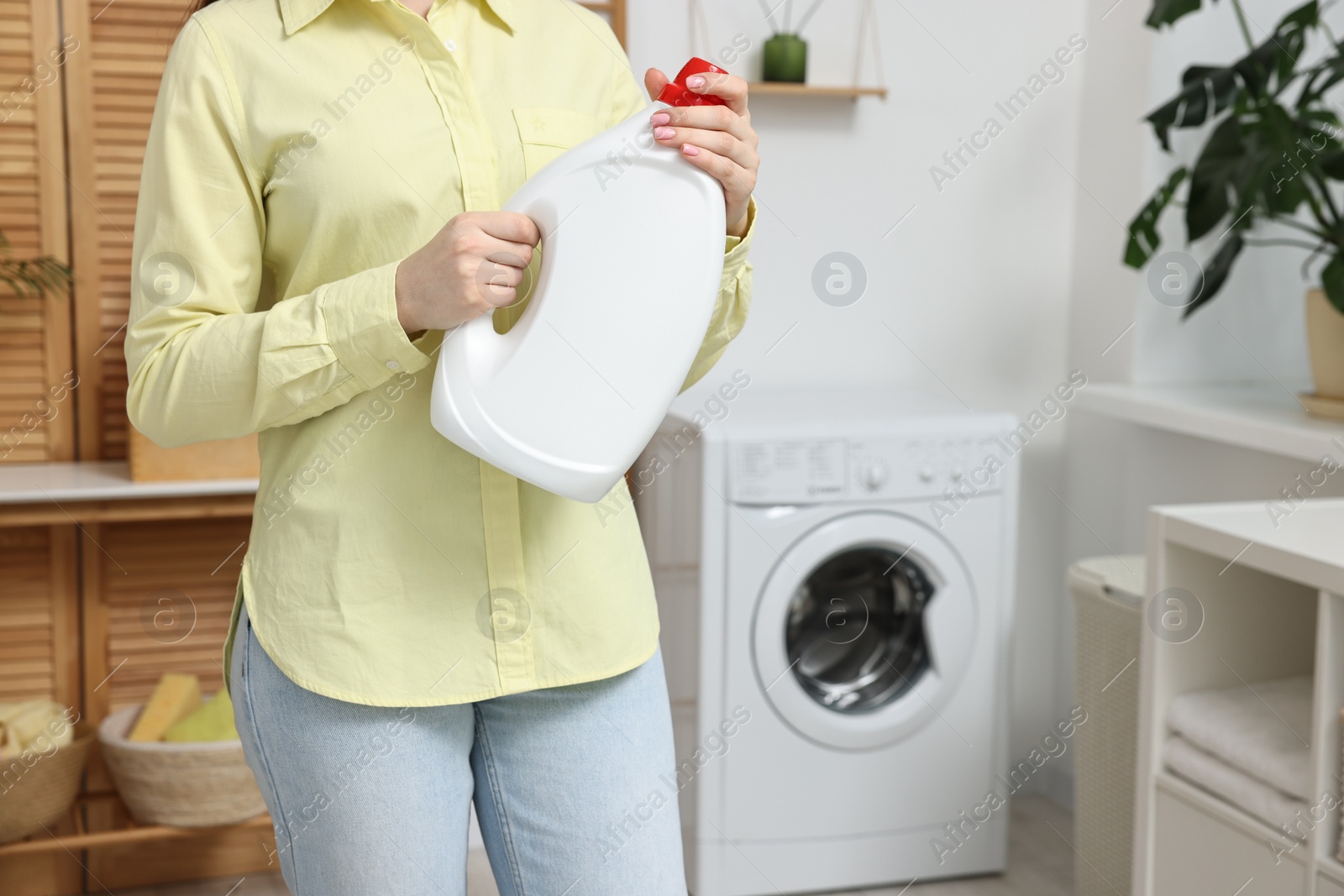 Photo of Woman with detergent in laundry room, closeup. Space for text