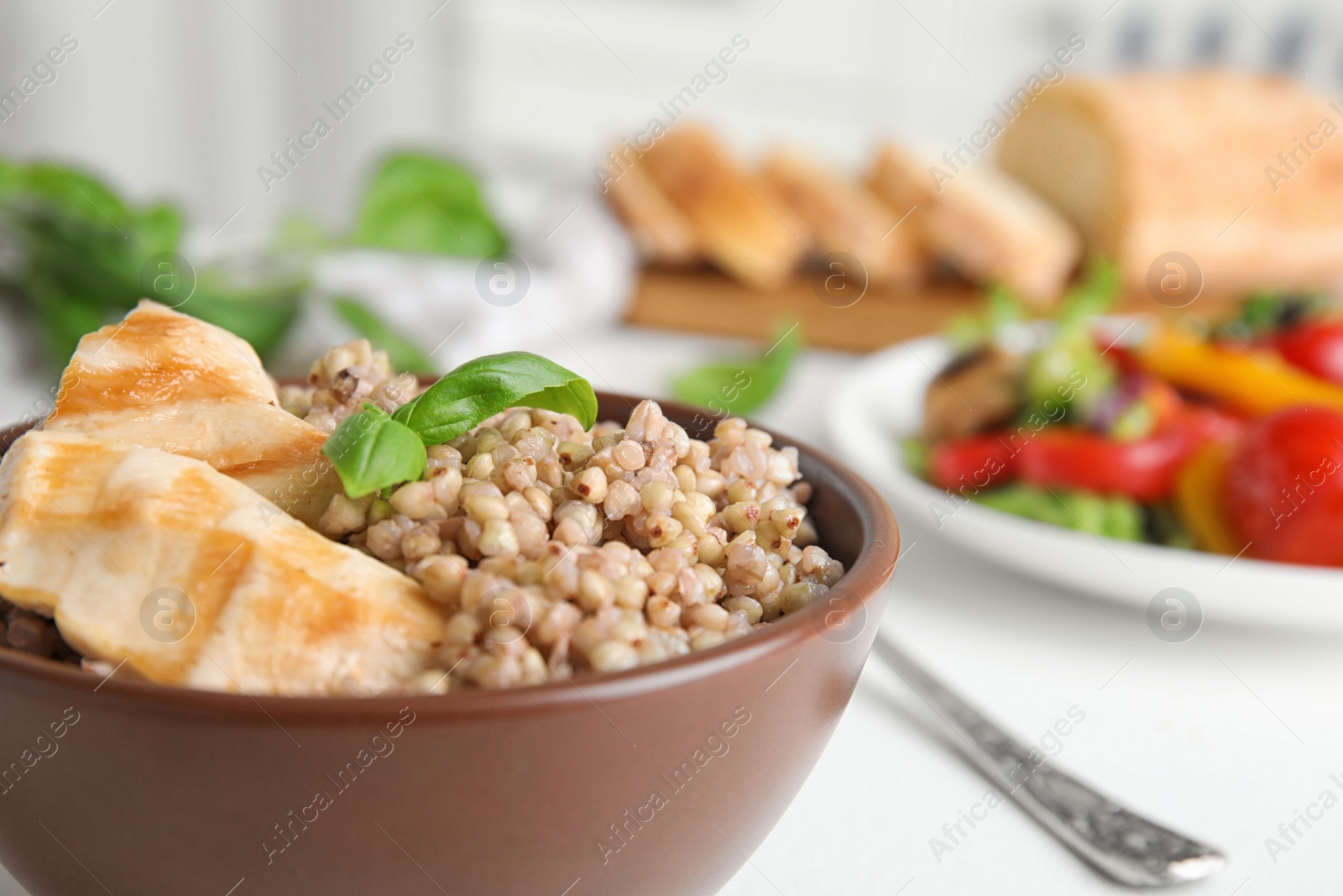 Photo of Bowl with tasty buckwheat porridge and meat, closeup