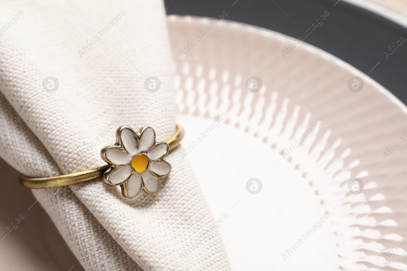 Photo of Fabric napkin and decorative ring on plate, closeup. Space for text