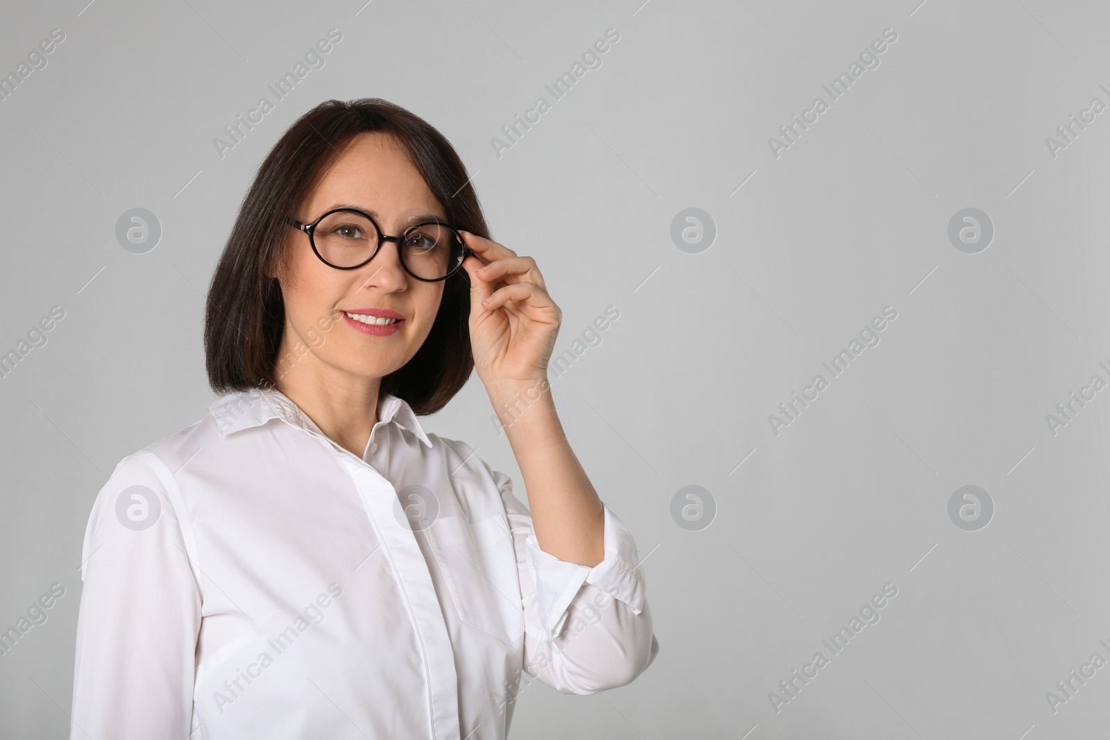 Photo of Portrait of mature businesswoman on light grey background. Space for text