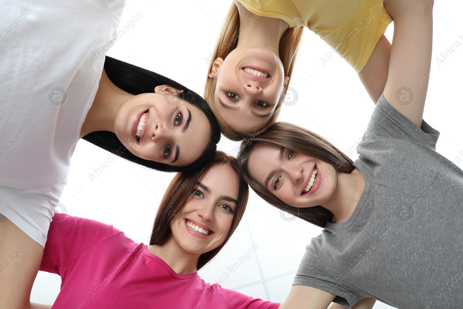 Photo of Beautiful young ladies hugging on white background, bottom view. Women's Day