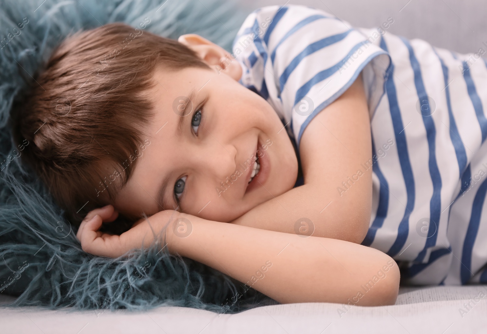 Photo of Cute little boy lying on sofa, closeup