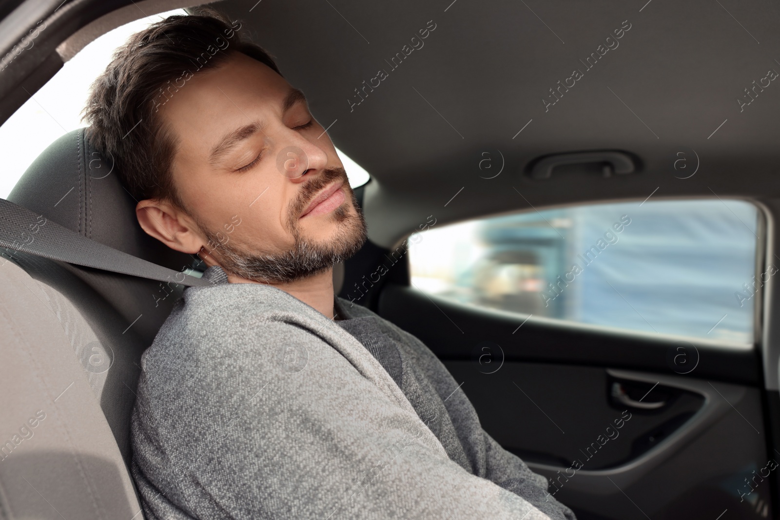 Photo of Tired handsome man sleeping in his modern car